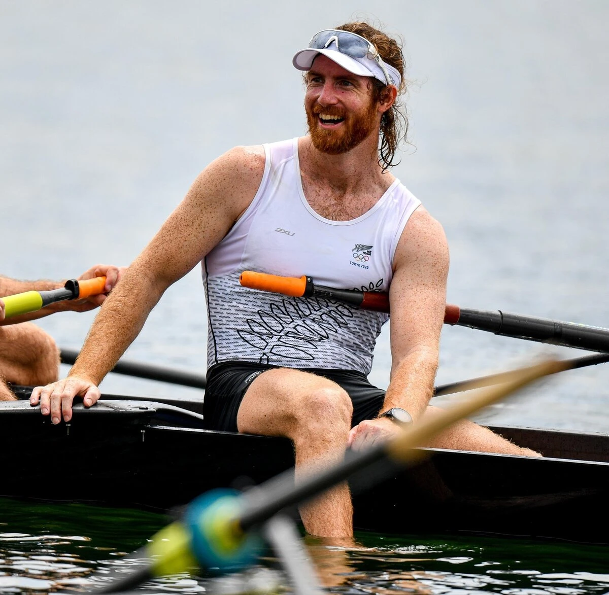 Shaun Kirkham smiling in a rowing boat, wearing his Tokyo 2020 singlet